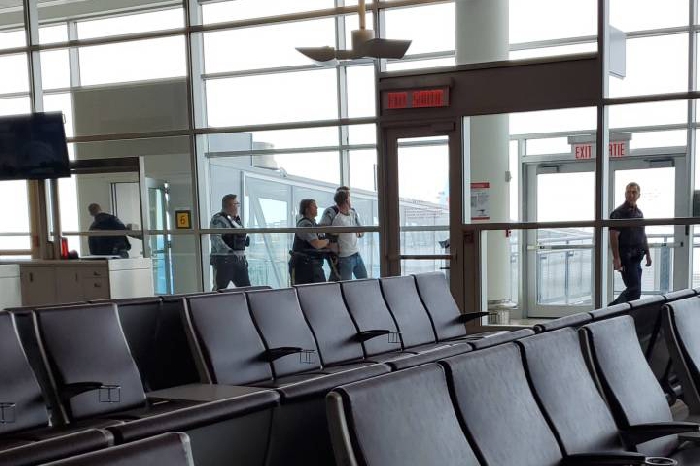 Ben James Iontton being let by RCMP through Winnipeg's airport after his arrest.